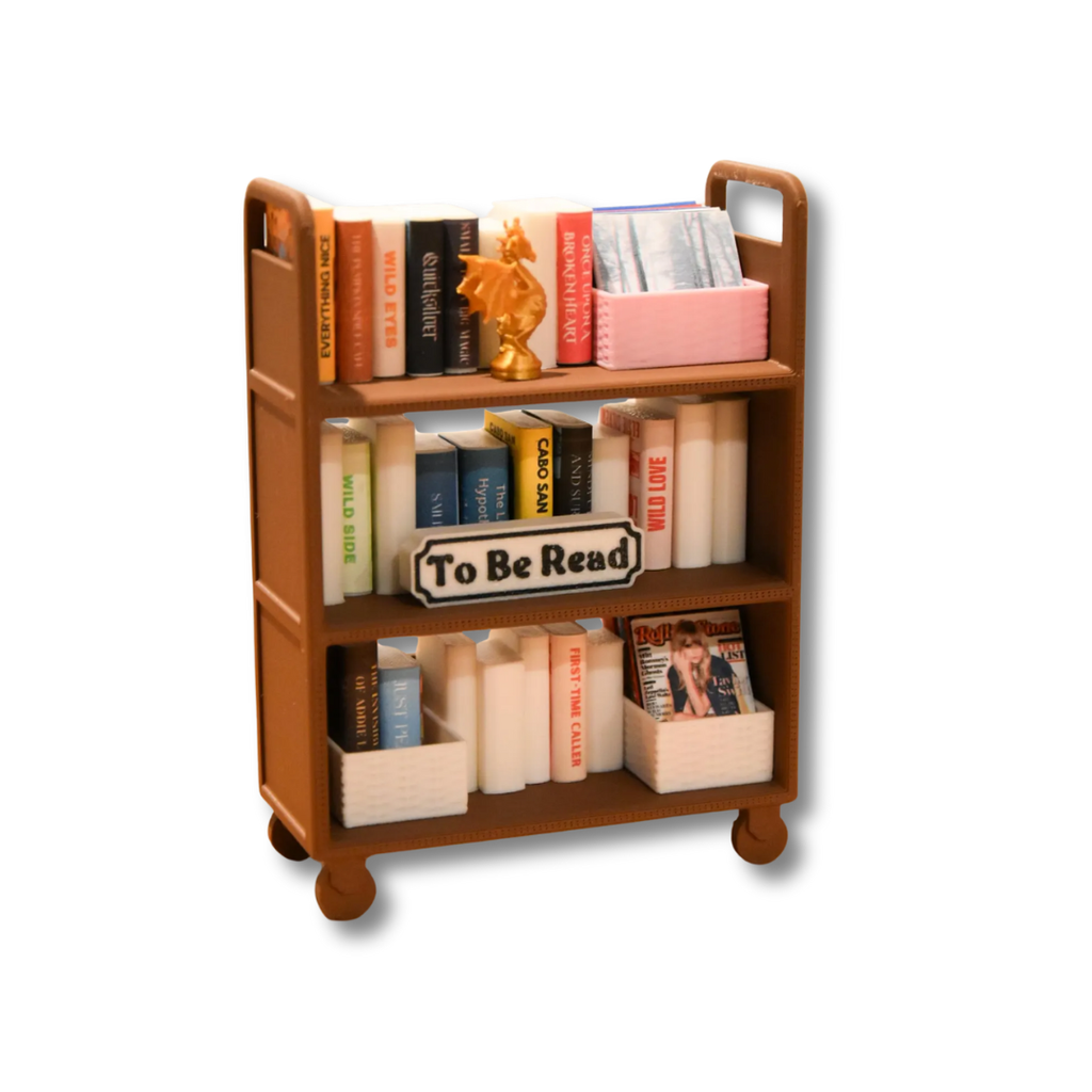 Mini library cart with books and a 'To Be Read' sign on a white background